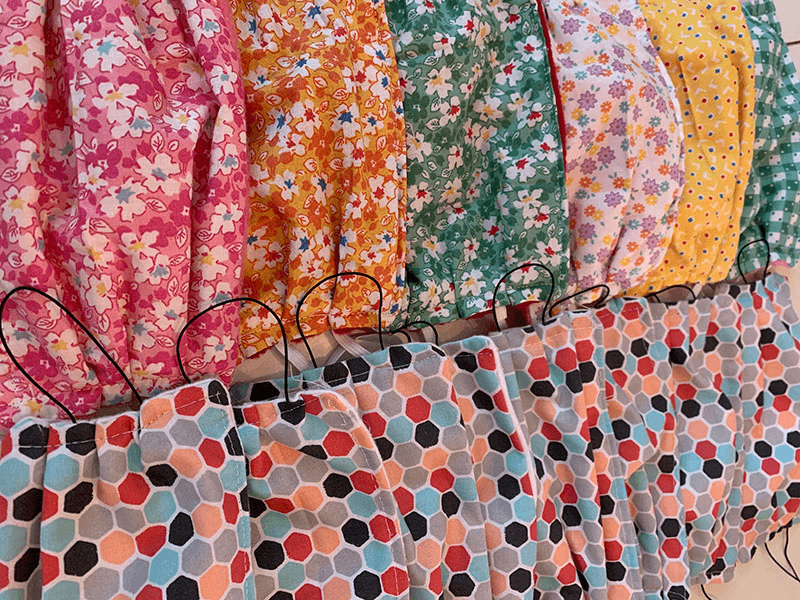 Rows of handmade cloth masks in colorful patterns